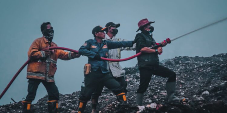 Steve Ewon bersama petugas saat memadamkan api di TPA Sarimukti beberapa waktu lalu